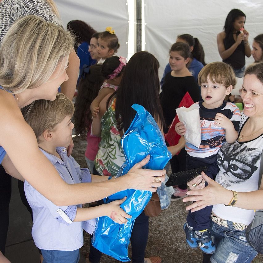 Smiling woman with a child at a table for volunteers.